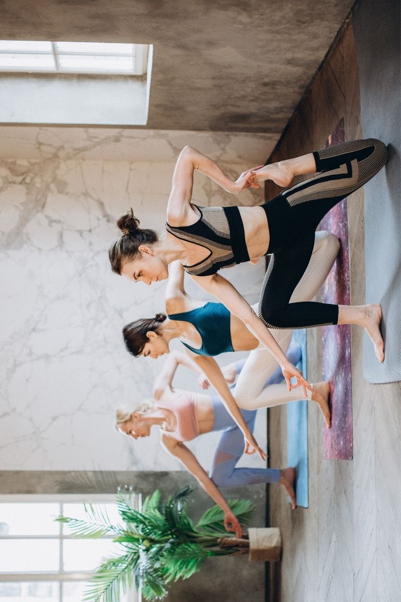 Kobiety robią ćwiczenia jogi na maćie do ćwiczeń