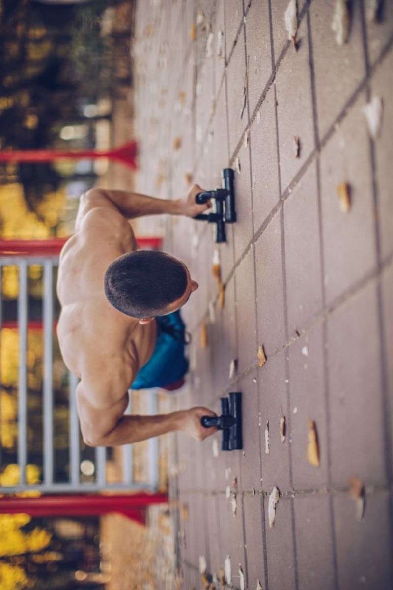 Ćwiczenie pompki z metalowymi uchwytami do pompek
