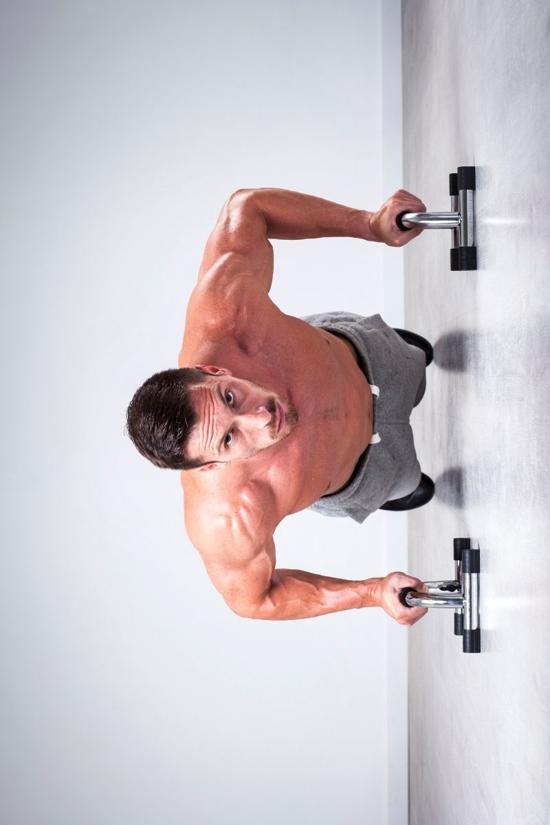 Trening sportowca z uchwytami do pompek